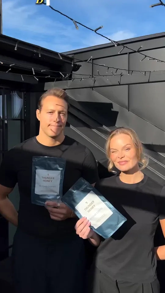 Joakim and Nina, the founders of Thunder Honey, on a rooftop in black t-shirts, each holding up a Daylight pouch