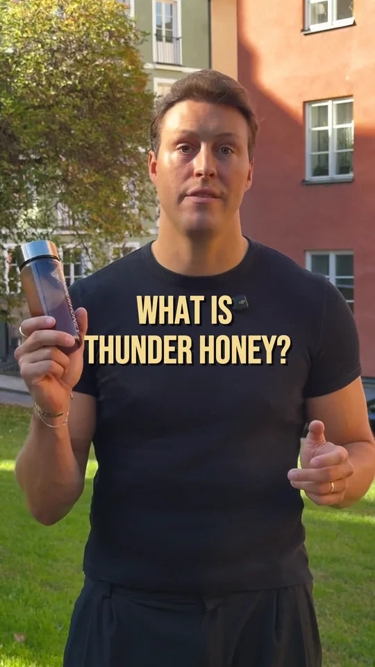 Joakim, one of the founders, in a black t-shirt in a city park, holding up a bottle of Thunder Honey under the words What is Thunder Honey?